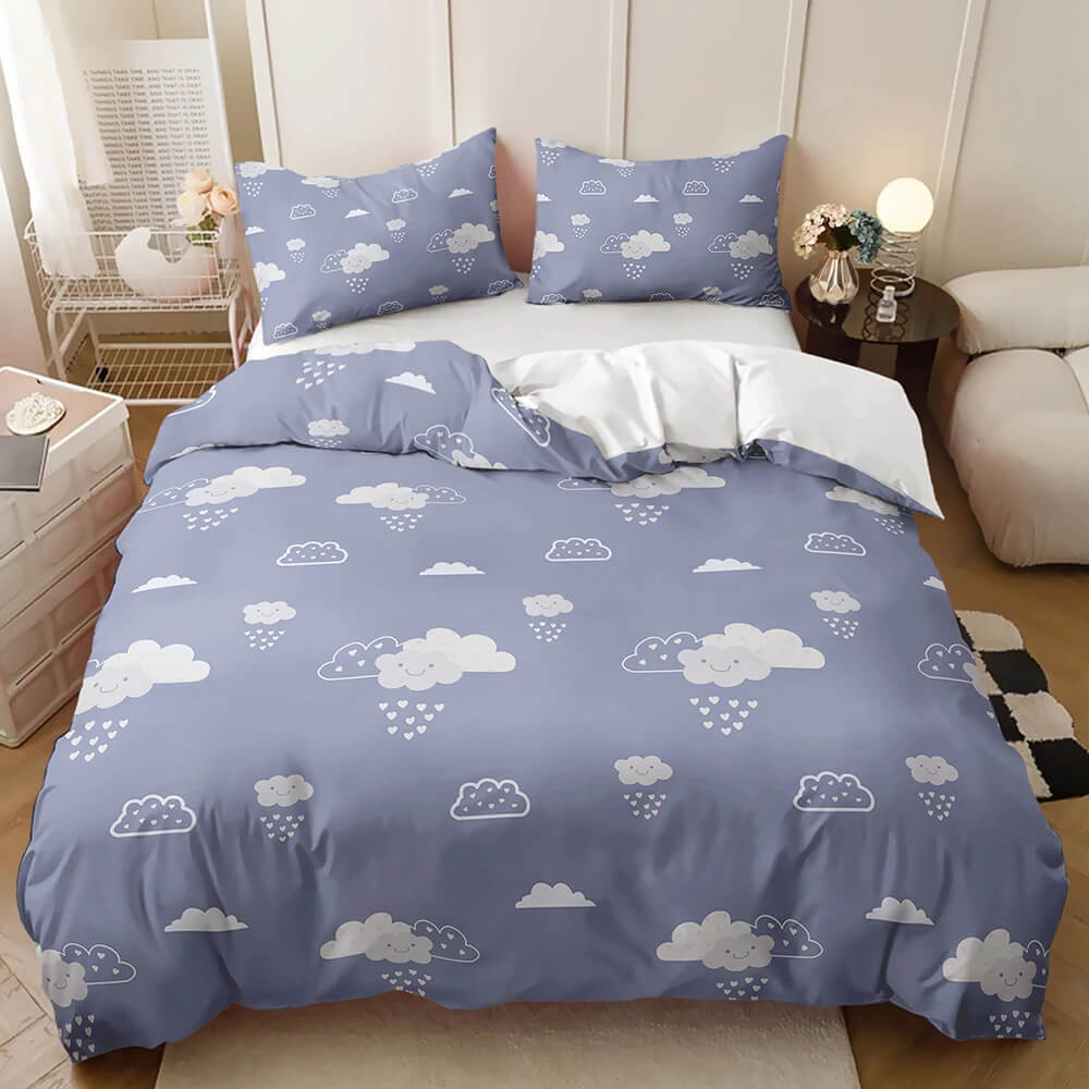 A blue bedding set with a white cloud and raindrop pattern, styled on a bed in a modern bedroom setting.