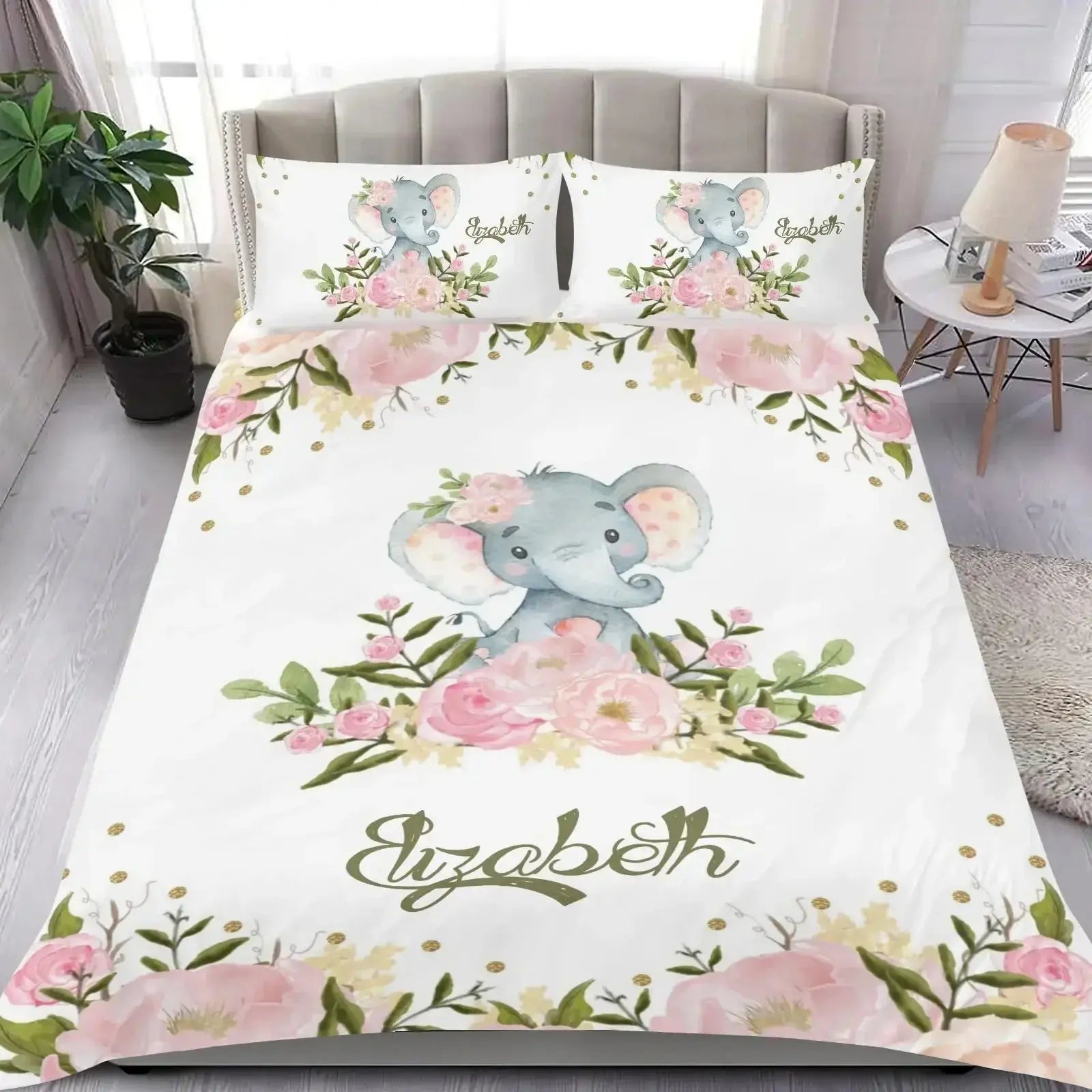Bedding set featuring elephant and floral design with name printed, displayed on a bed in a bedroom setting
