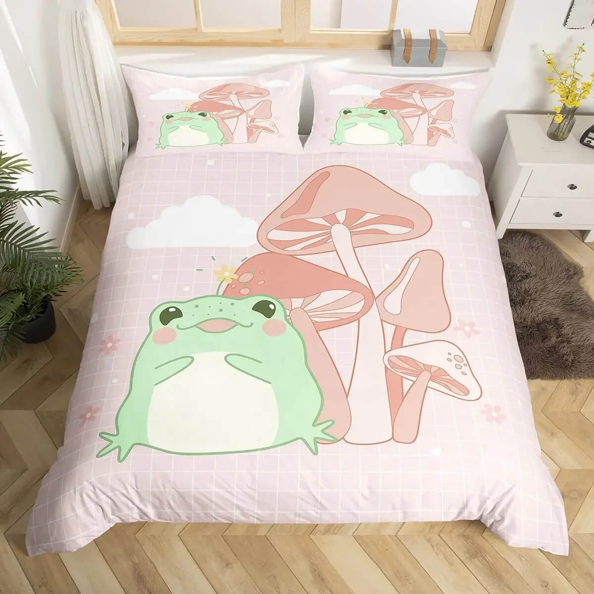 A pink bedding set with a cute cartoon frog and mushroom design, shown on a bed in a styled bedroom setting.