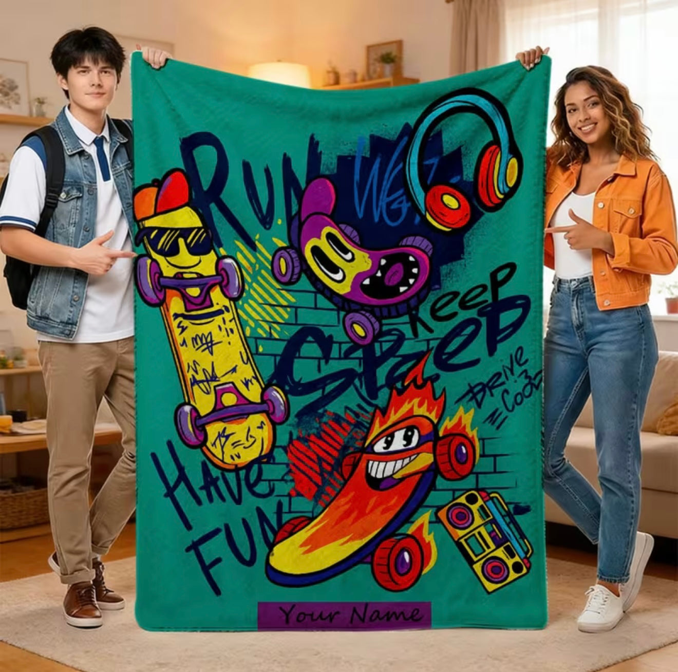 Two people holding a colorful blanket with cartoon skateboards and text in a living room.