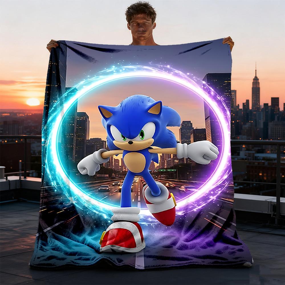 A man holds up a large printed blanket or tapestry featuring Sonic the Hedgehog in front of a city skyline at sunset. Because a person and a real environment are visible, this is classified as Lifestyle rather than Product/Packaging, even though the product itself is clearly shown.