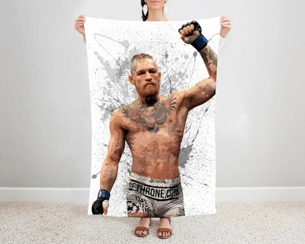 Conor McGregor splash effect flannel blanket featuring bold UFC fighter artwork, ultra-soft and warm fabric, perfect for MMA fans’ bedding, couch throw, or combat sports gift