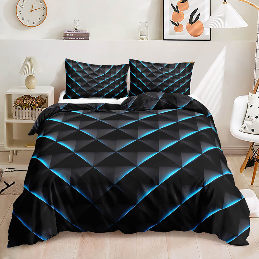 A bed dressed in a black bedding set with a bold blue glowing geometric diamond pattern, styled in a bright modern bedroom with a nightstand, lamp, and wall art.