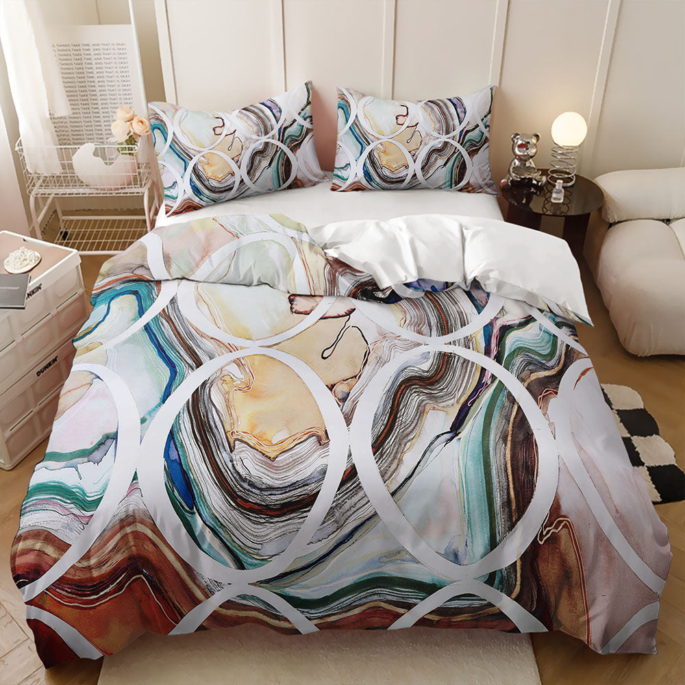 A bedding set with a colorful abstract marble and agate-inspired print, styled on a bed in a modern, light-filled bedroom.