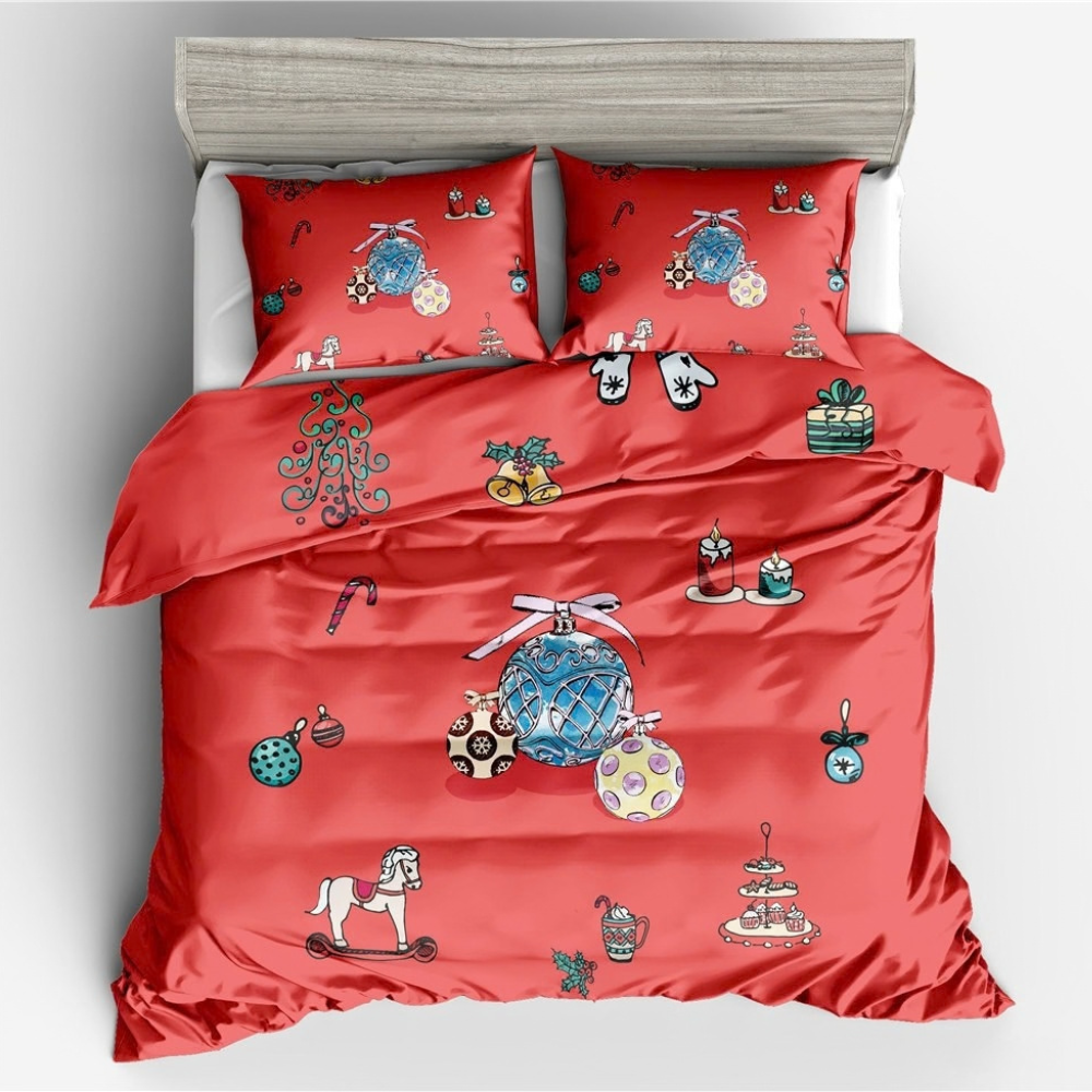 A red bedding set with matching pillowcases featuring a Christmas-themed pattern of ornaments, candy canes, gifts, and holiday decorations, displayed on a bed with a gray headboard.