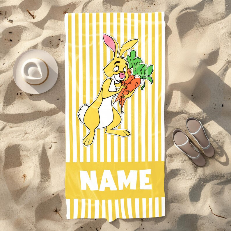 Custom Rabbit beach towel with yellow and white stripes, showing Rabbit from Winnie the Pooh holding carrots, with space for a personalized name.