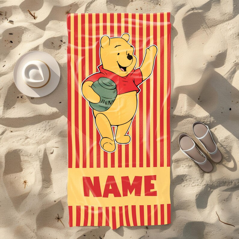 Custom Winnie the Pooh personalized beach towel with red and yellow stripes, featuring Pooh holding a honey jar and space to add a child's name.