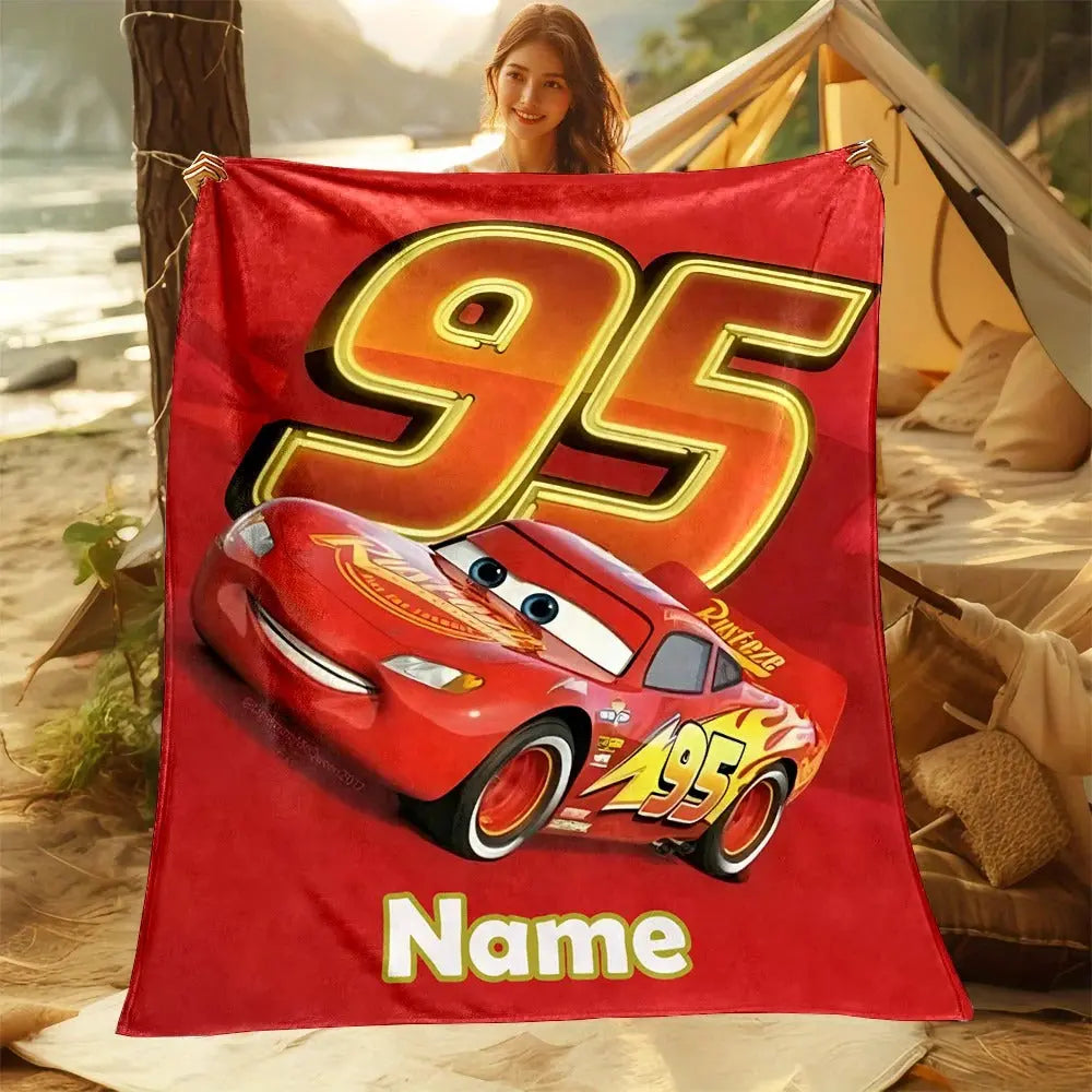 Boys cartoon fleece blanket featuring Lightning McQueen and personalized name, displayed in a cozy kids’ room