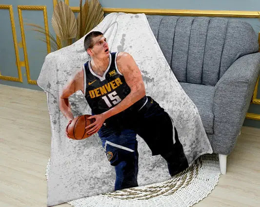 Nikola Jokić splash effect flannel blanket featuring vibrant NBA graphics, ultra-soft warm fabric, and bold Denver Nuggets-themed design perfect for basketball fans’ bedding or couch throw