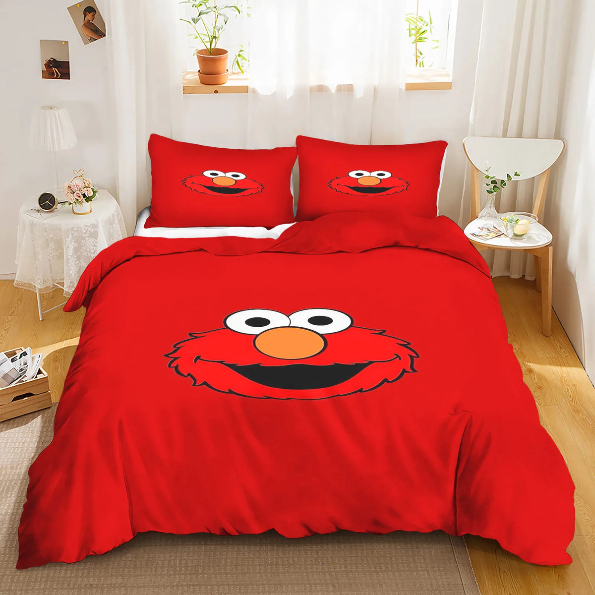 Elmo waving with a big smile, surrounded by colorful stars and letters on the bedding.