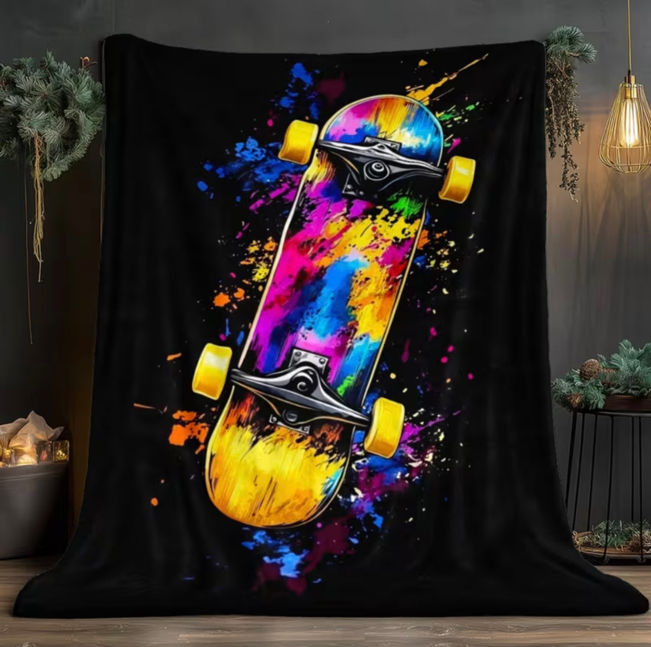 Colorful skateboard design on a black blanket with abstract paint splashes.