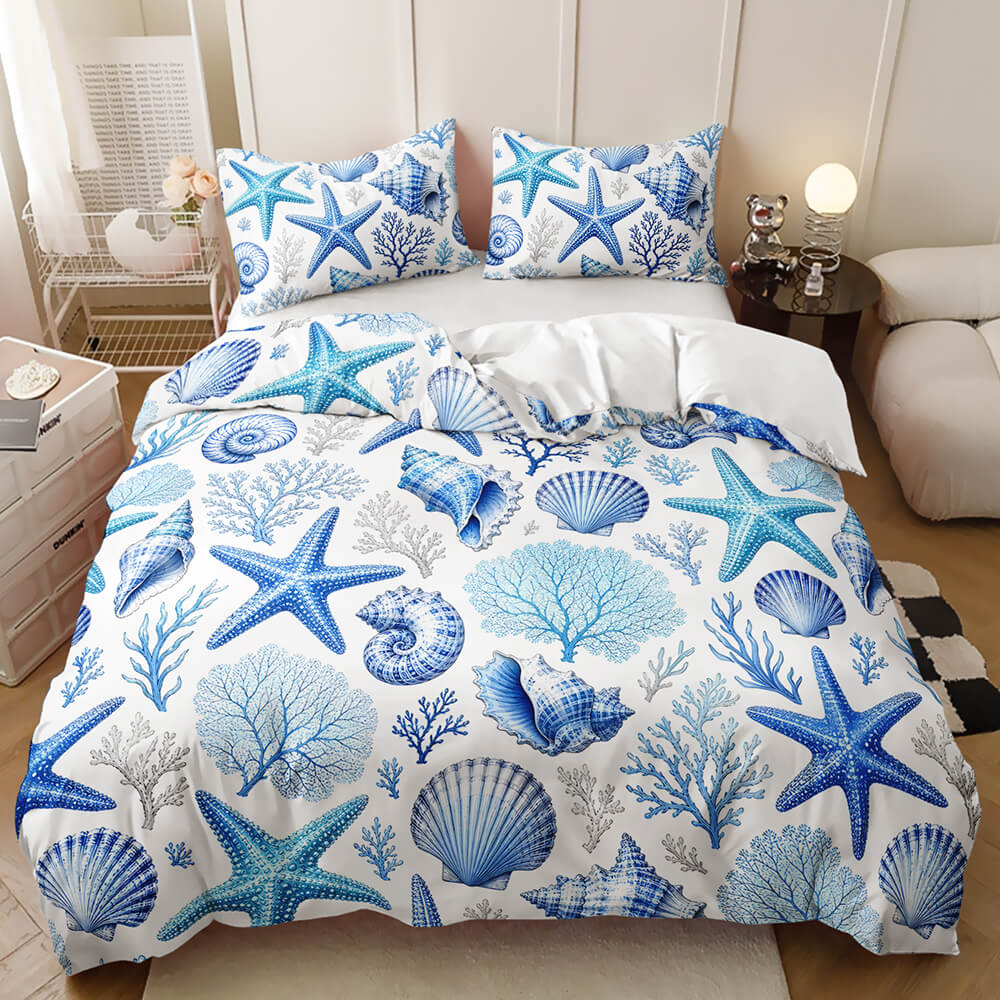 Ocean animal bedding blue and gray nautical print with starfish, seashells, and coral, styled in a bedroom setting.