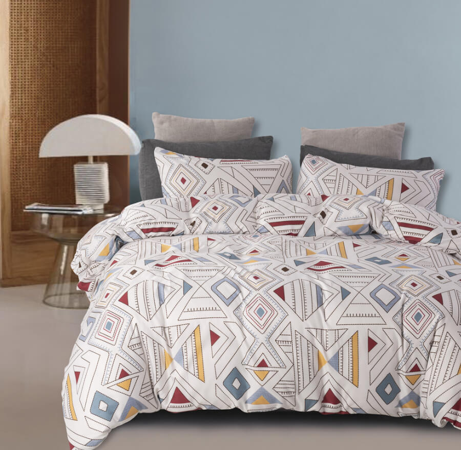 A bed dressed in a white duvet cover and matching pillowcases featuring a colorful geometric diamond pattern, styled in a bedroom setting