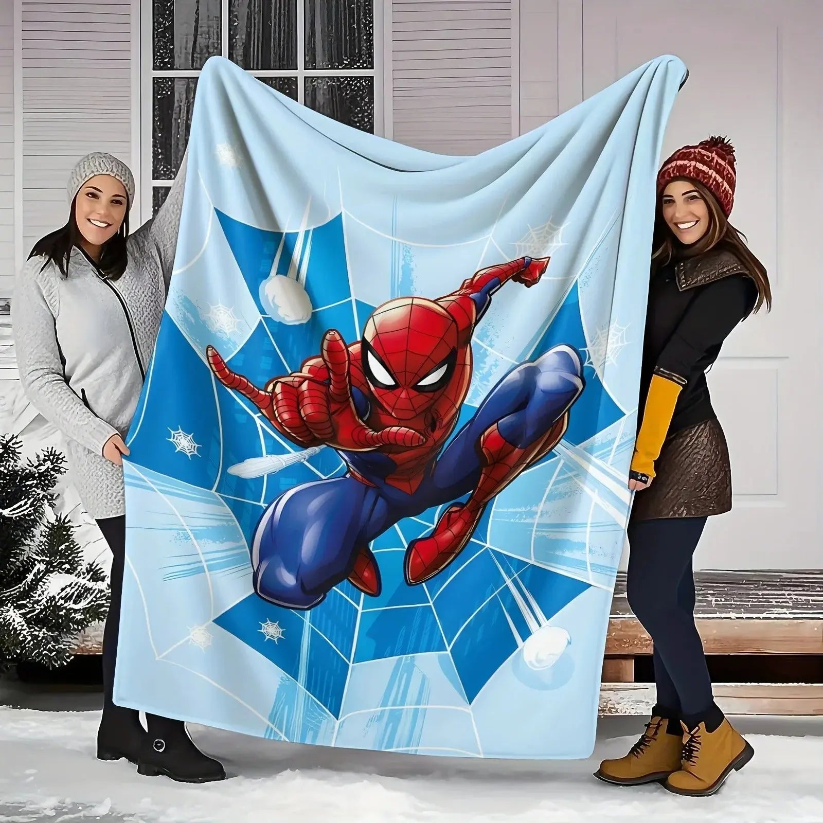 Spider-Man blanket laid on a bed with matching superhero-themed pillow