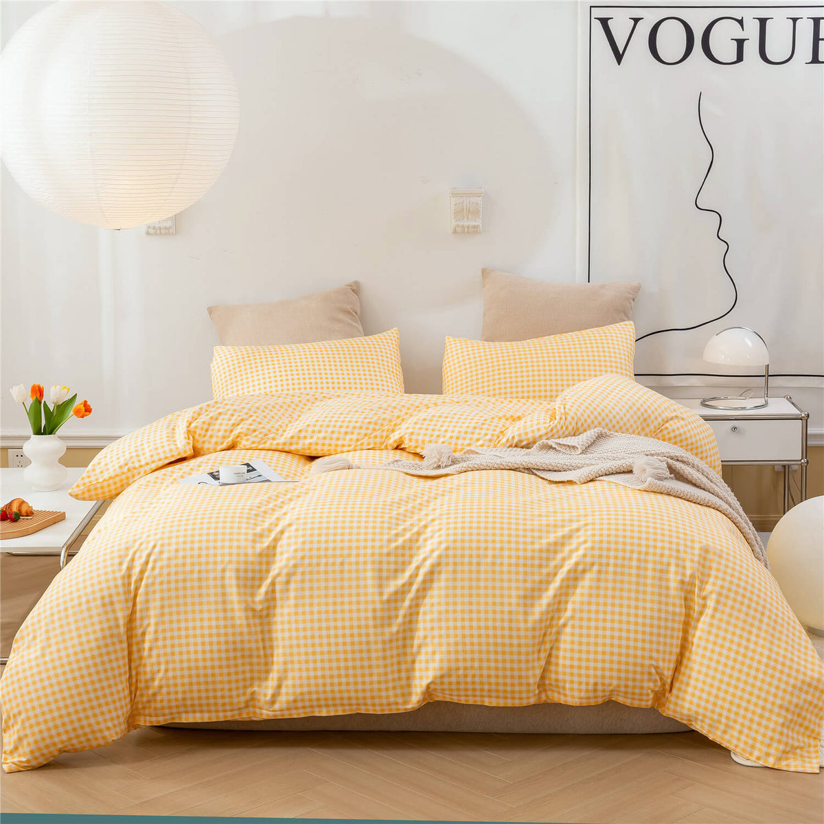 A yellow and white gingham check bedding set, including a duvet cover and matching pillowcases, styled on a bed in a bright, modern bedroom