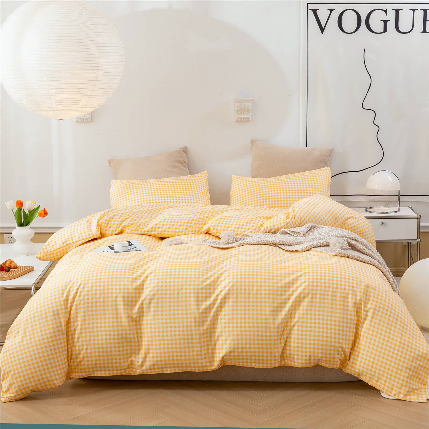 A yellow and white gingham check bedding set, including a duvet cover and matching pillowcases, styled on a bed in a bright, modern bedroom