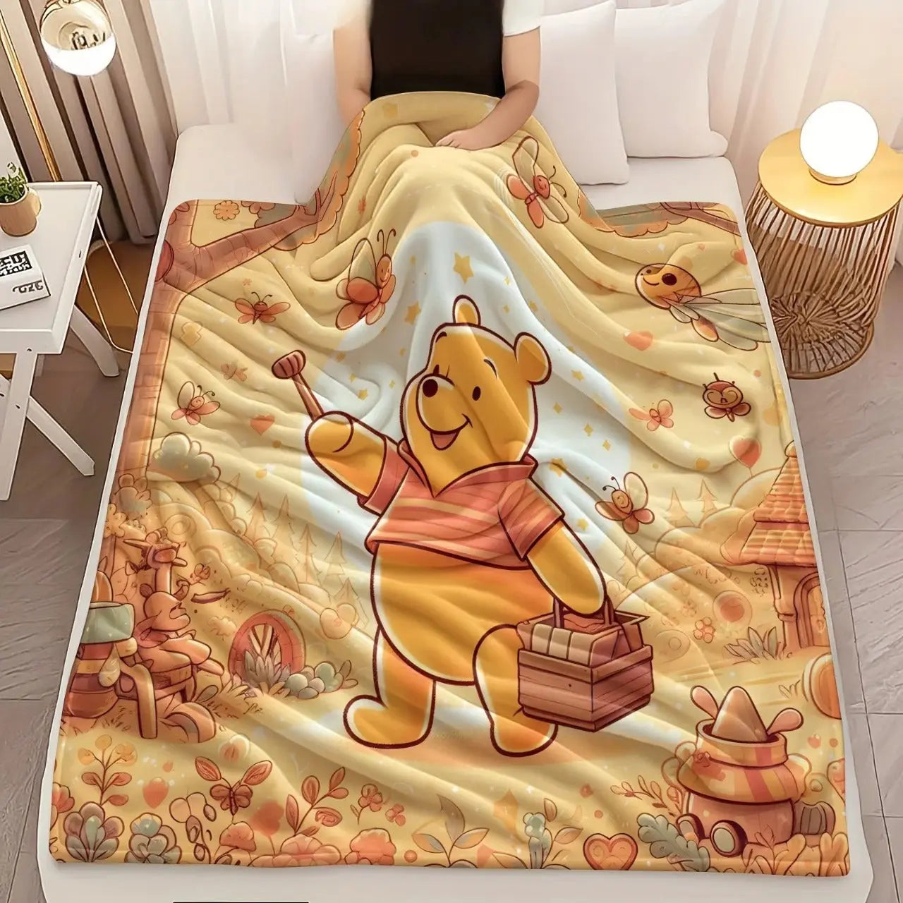 Winnie the Pooh fleece throw blanket folded on a bed with soft pillows